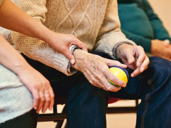 Elderly hand holding ball