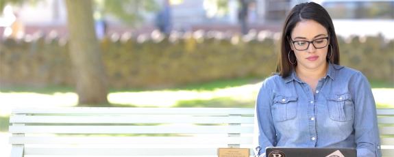 Student studying on campus park bench